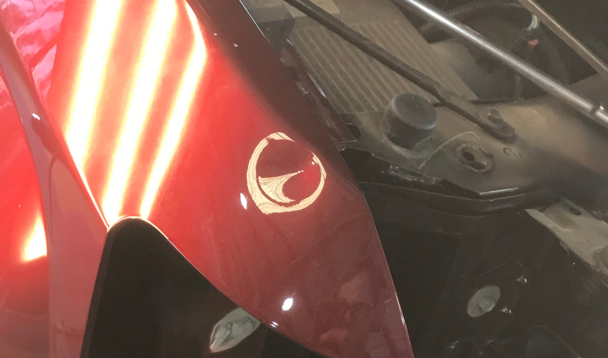 Before: Hood dent smoothed and restored without paint or filler