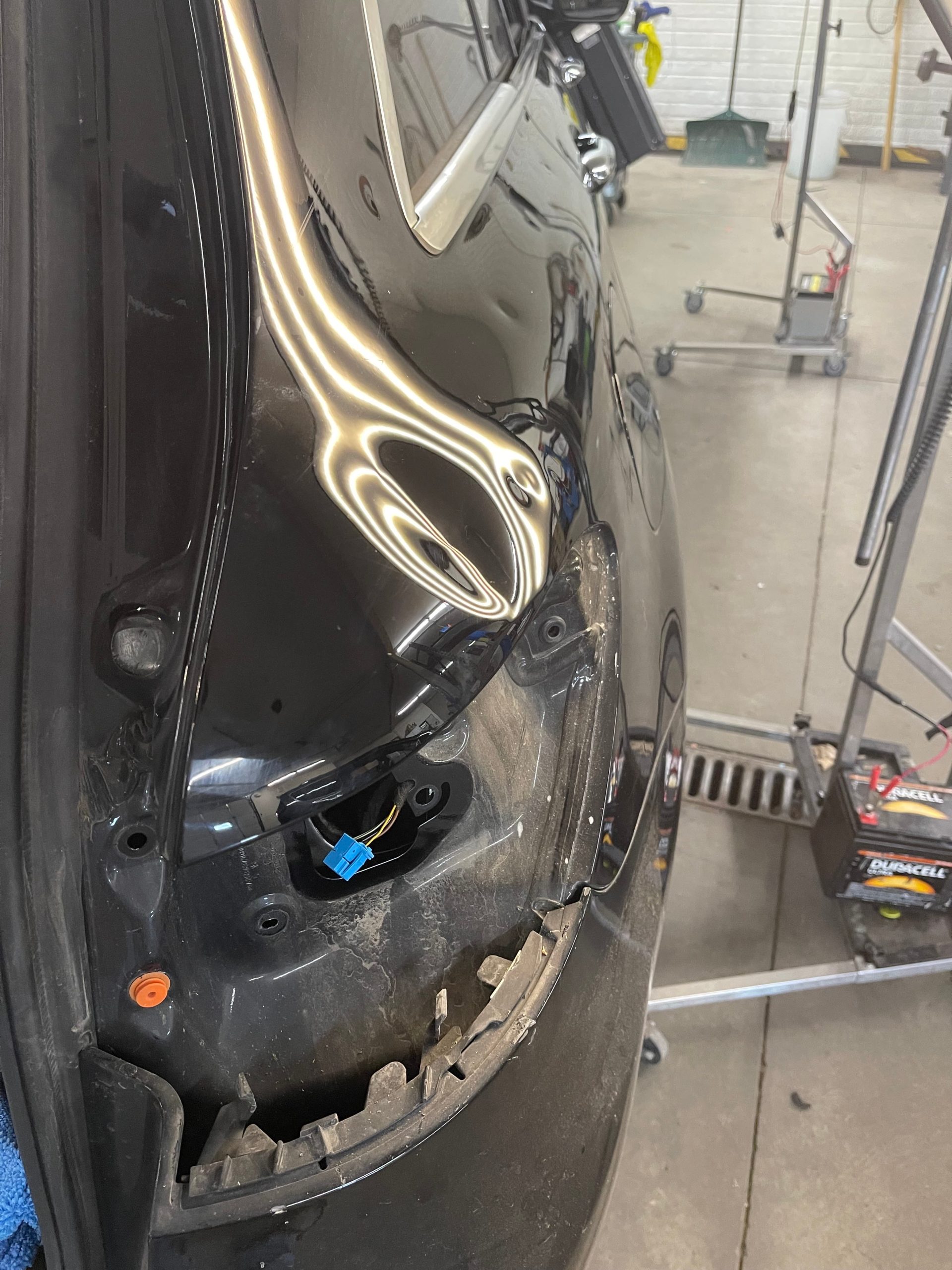 Before: Fender dent restored to smooth factory finish