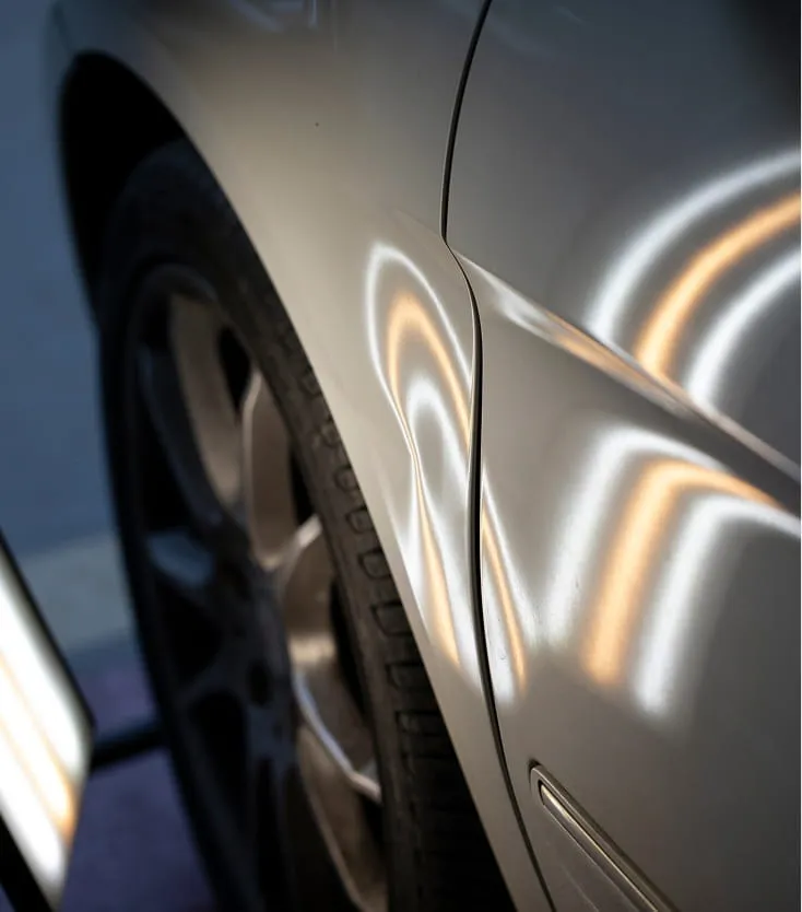 Clear large dents visible near a wheel of a vehicle